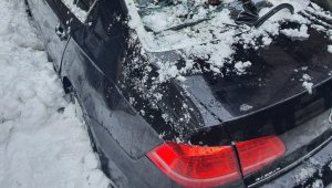 Otomobili çatıdan düşen kar kütlesiyle 1 dakika sonra kullanılamaz hale geldi